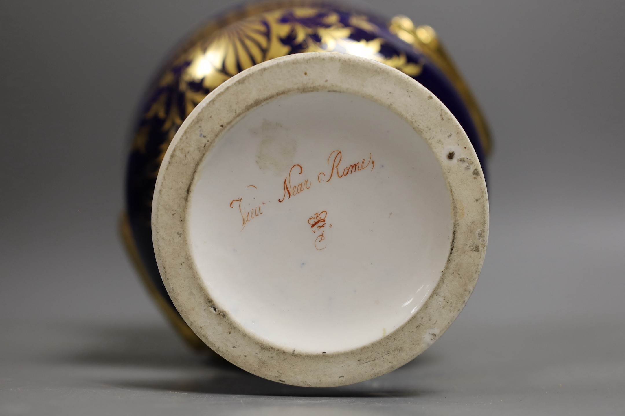 A garniture of three Derby named twin handled cups, View near Belper, Derbyshire, and 'View in North Wales' and 'View near Rome', 17cm and 20.5cm
